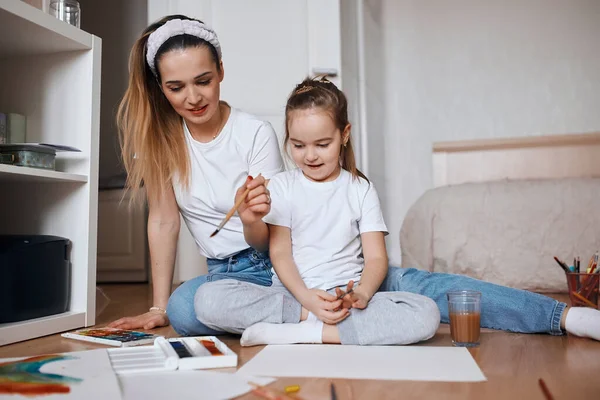 Gelukkige familie. Moeder en dochter hebben tekenles — Stockfoto