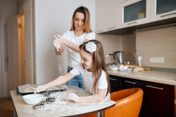 little girl and her mother having flour party