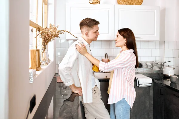 Couple talking and drinking tea in their kitchen — Stock Photo, Image