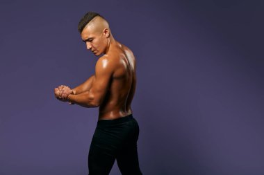 Güçlü yakışıklı stil sahibi atletik adam kaslarını ve kaslarını gösteriyor.