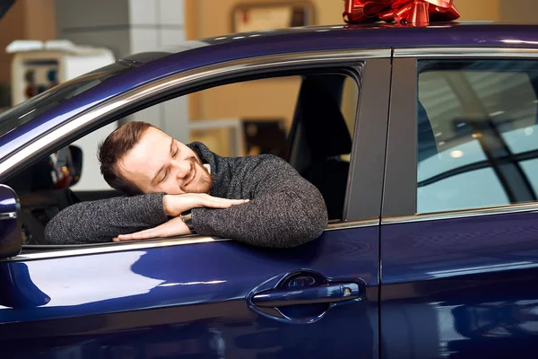 Fröhlicher bärtiger Kunde liegt auf dem Auto — Stockfoto
