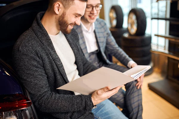 Glücklicher Mann genießt Kaufvorgang im Autohaus — Stockfoto