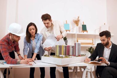 group of young clever people works at the market of wooden housing construction