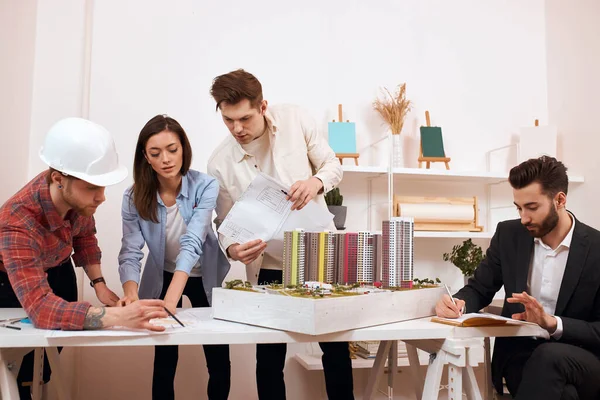 group of young clever people works at the market of wooden housing construction