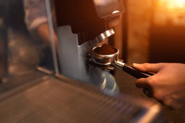 young man holding portafilter and testing new coffee maker