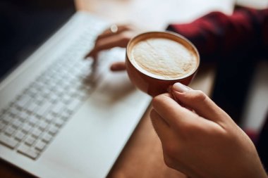 guy holding a cup of latte with heart shape