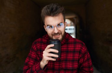cheerful pleasant guy holding acup of latte