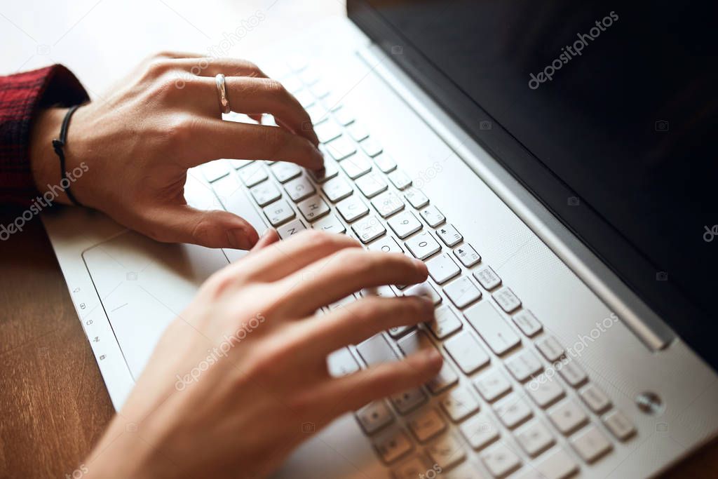 Corporate male using laptop, typing business report. Cropped image.
