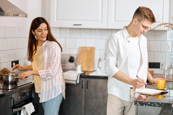 Young smiling girl looking back, controlling her husband work — Stock Photo, Image