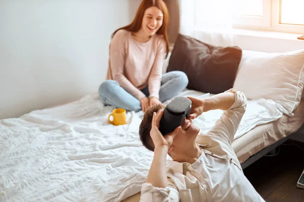 Funny young man sitting on the floor and using virtual reality goggles — Stock Photo, Image