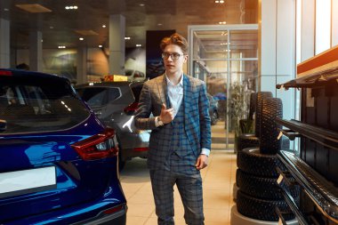 stylish young macho posing to the camera while waiting for customers