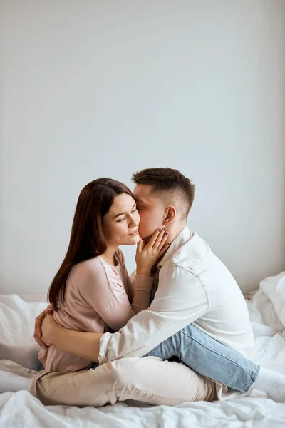 Jovem casal beijando, abraçando na cama — Fotografia de Stock