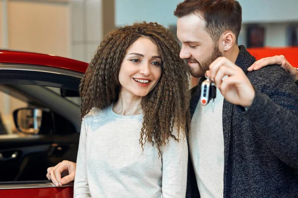 Handsome smiling man giving keys to his woman — Stockfoto