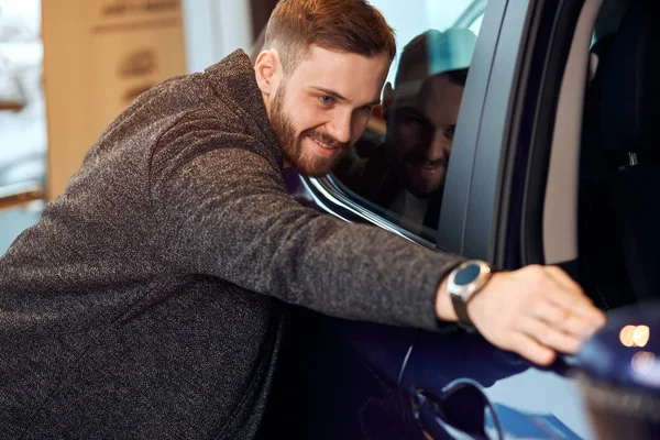 Lächelnder positiver Typ, der sein Auto umarmt, putzt, Auto wischt, bevor er reist — Stockfoto
