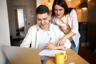 attractive loving couple looking at the laptop in the kitchen