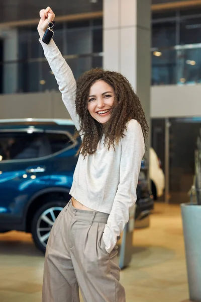 Good looking awesome girl rising her keys of the luxury car — Stockfoto