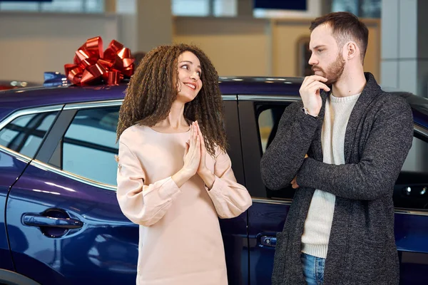 serious puzzled man touching his chin doesnt want to buy expensive car