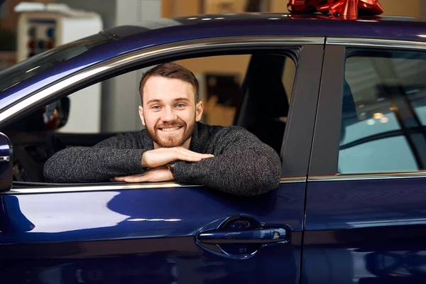 Bearded happy man sitting in newly bought car — Stockfoto