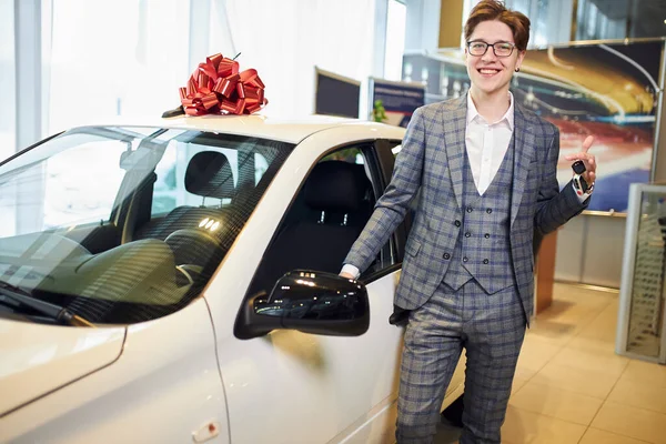 Happy handsome stylish dealer in gray checvked suit holding car keys — Stockfoto