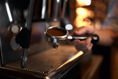 Grounded coffee in a portafilter. barista making coffee