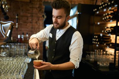 young barista enjoying making cuppuchino at workplace
