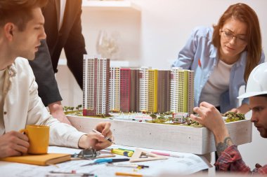 business people looking at building model and blueprint