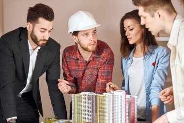 young talented male architect explaining his colleague the features of deal
