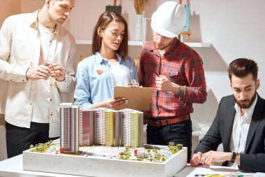 talented architect in red shirt consulting his colleagues
