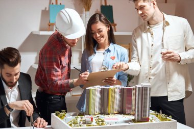 excited group of young architects collaborating on common project
