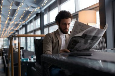 bearded attractive guy holding a newspaper
