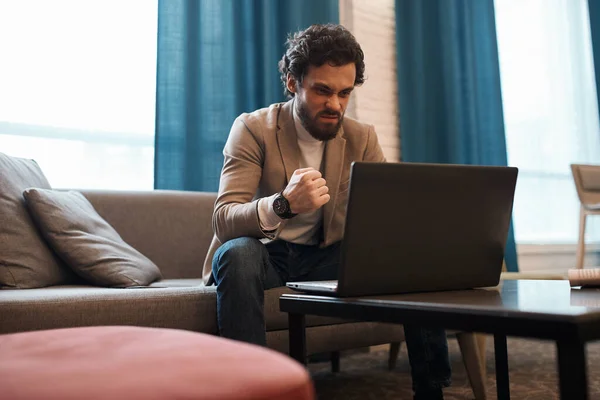 Angry man sitting in front of the laptop — Stockfoto