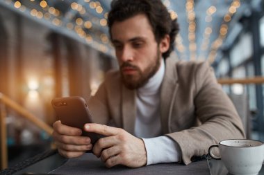 focus on the smart phone blurred image, guy doing shopping online