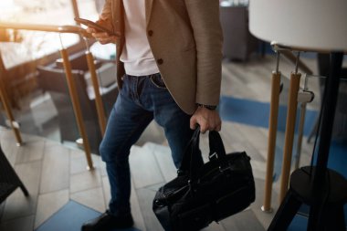 Businessman using mobile phone while walking in the office