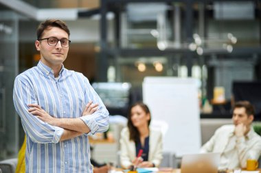 handsome man in striped blue and white cshirt posing to the camera
