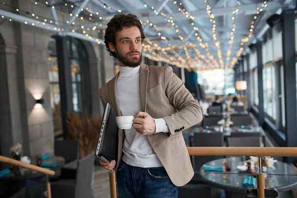 Pleased cheerful young man looking at the window — Stockfoto