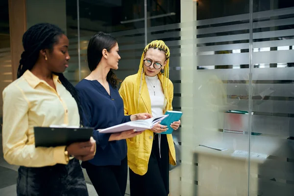 Trois belles femmes d'affaires marchant dans le bureau et discutant du projet — Photo