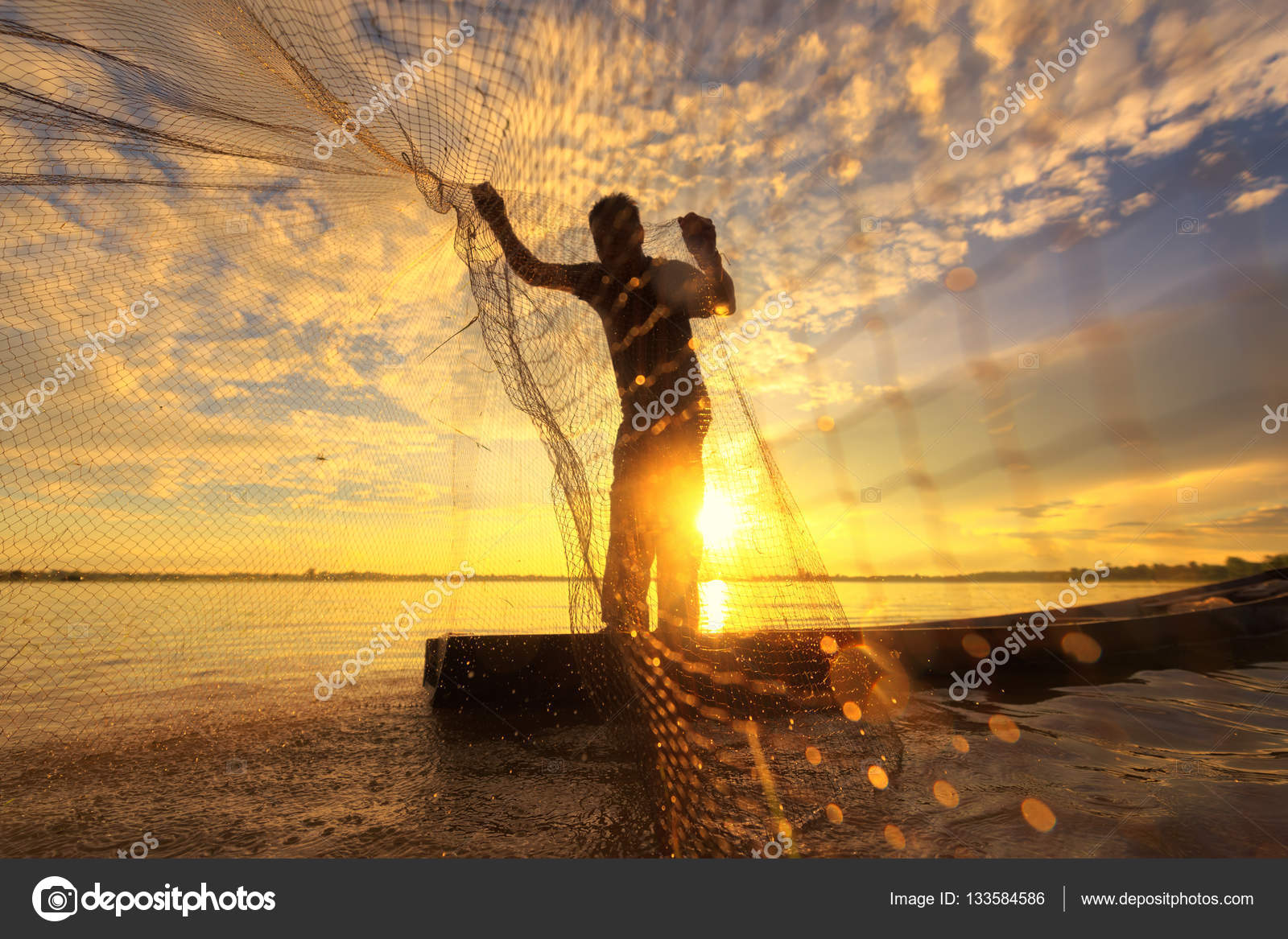 Silhouette of traditional fisherman throwing net fishing lake at
