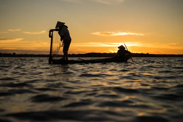 Силуэт традиционного рыбака, бросающего сетчатое рыбацкое озеро в — стоковое фото