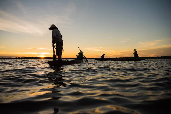 Silhouette de pêcheur traditionnel jetant filet lac de pêche à — Photo