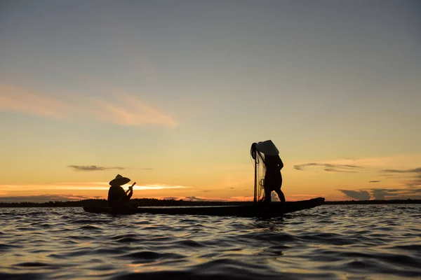 Silhouette de pêcheur traditionnel jetant filet lac de pêche à — Photo