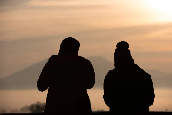 Silhouette of tourist couple with dramatic shine a mountain enjo — Stock Photo, Image