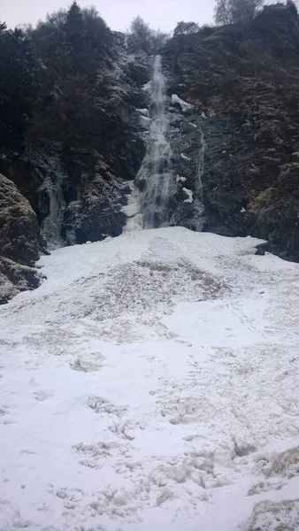 Tekoucí vodopád v zimě s tkalcovským ledem — Stock fotografie