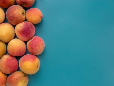 Mavi arka planda sulu kayısılar.