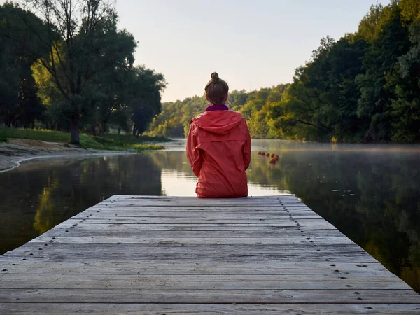 Kız sabahın erken saatlerinde nehre bakıyor..