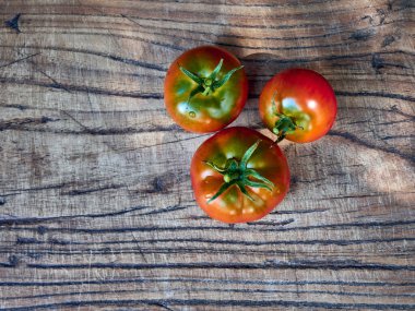 Ahşap zemin üzerinde taze olgun domatesler..