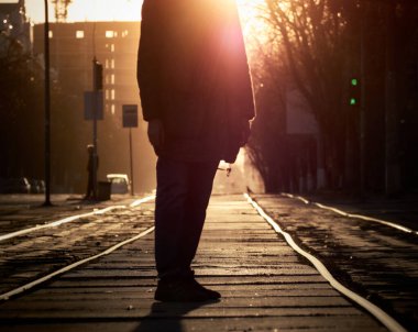 Gün batımında raylarda bir adam.