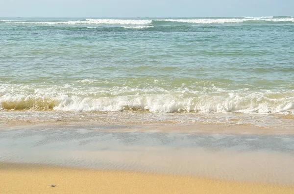 Гладкий песок на пляже с пеной океана — стоковое фото