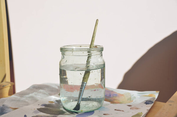 Paintbrush in jar with clean water 