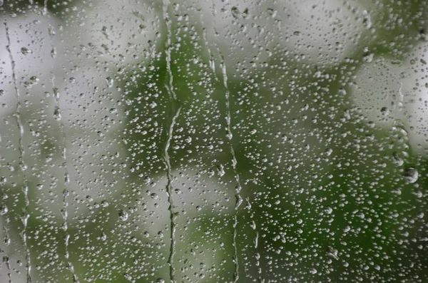 Gocce di pioggia sulla finestra in autunno sera — Foto Stock