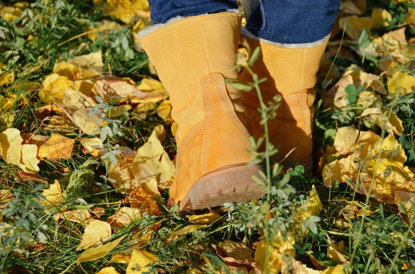 Gambe di ragazza in stivali hipster sulle foglie autunnali. Luminoso stile indipendente e hipster — Foto Stock